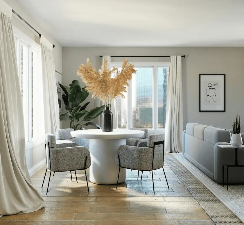 A bright living and dining area features a white round dining table with four gray chairs, a light gray sofa, and large windows offering a city view.